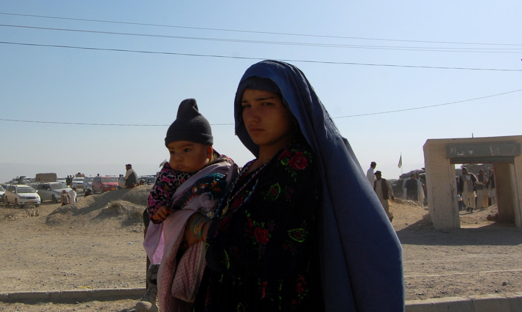 Afghan refugee women Bibi Rakema carry her daughter towards with his father to cross the Friendship gate on Pak-Afghan border Chaman, going to Afghanistan from Pakistan on Tuesday 06 January 2015. Photo by Matiullah Achakzai.